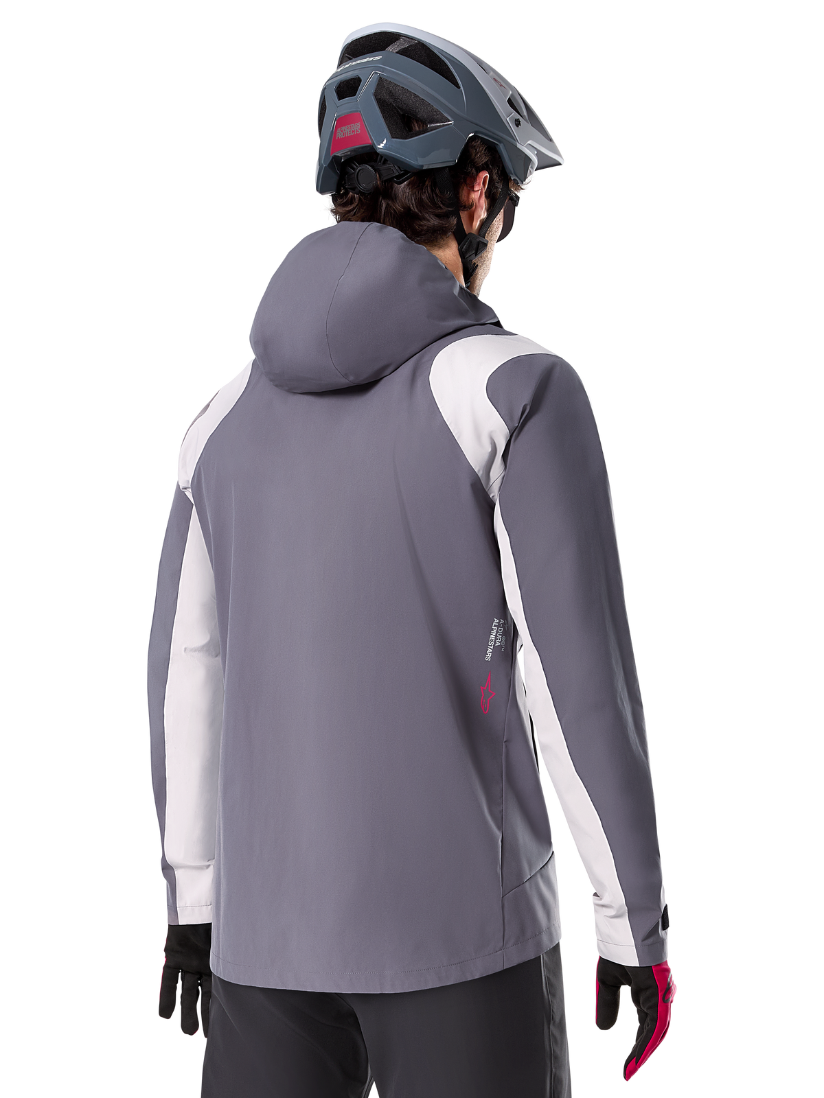 Alpinestars A-Dura Rain Jacket, kurtka przeciwdeszczowa MTB, ciemnoszara (Dark Titanium), widok z tyłu z jasnoszarymi panelami na ramionach i rękawach, czerwone logo z boku, noszona z szarym kaskiem MTB i czarno-czerwonymi rękawicami, techniczna odzież trailowa