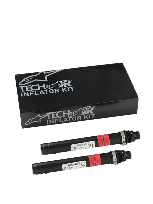Alpinestars Tech-Air 3 V2 Airbag System Replacement Canisters, dwa czarne cylindryczne napełniacze z gazem argonowym z czerwonymi etykietami ostrzegawczymi, czarne pudełko Tech-Air Inflator Kit ze srebrnym brandingiem Alpinestars, niezbędny zestaw serwisowy do motocyklowych systemów poduszek powietrznych