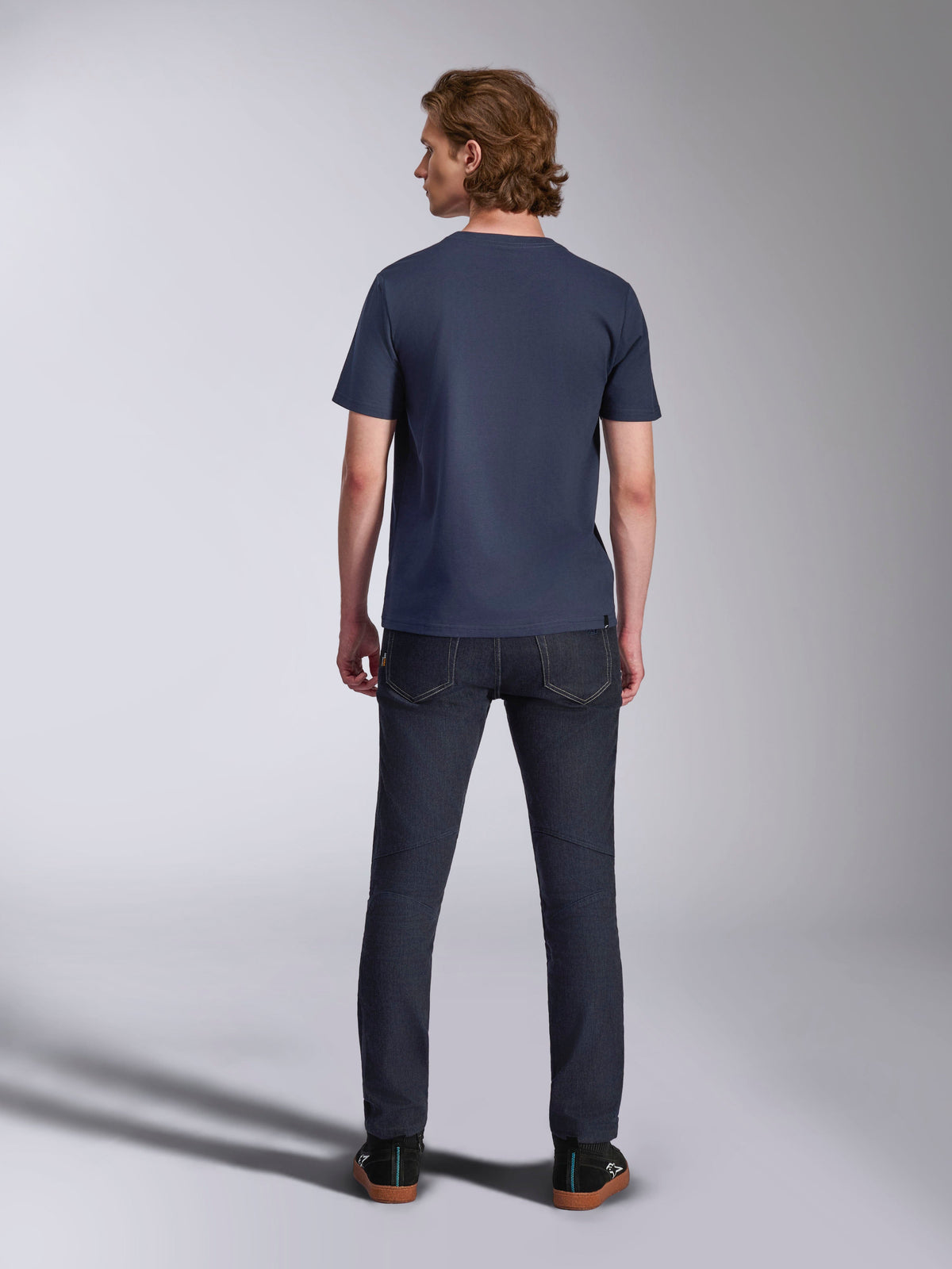 Alpinestars Ageless 2.0 CSF Tee, Short Sleeve T-Shirt, Navy, back view, worn by a man with dark denim jeans and black sneakers, casual motorsport-inspired streetwear