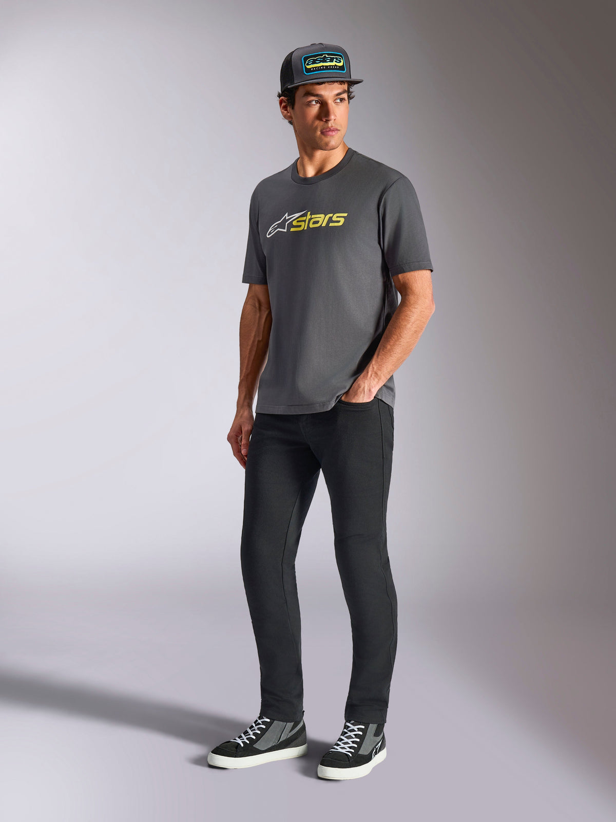 Alpinestars Blaze 2.0 CSF Tee, Short Sleeve T-Shirt, Charcoal Gray with White and Hi-Vis Yellow Logo, worn by model with black hat and pants, casual motorsport lifestyle apparel