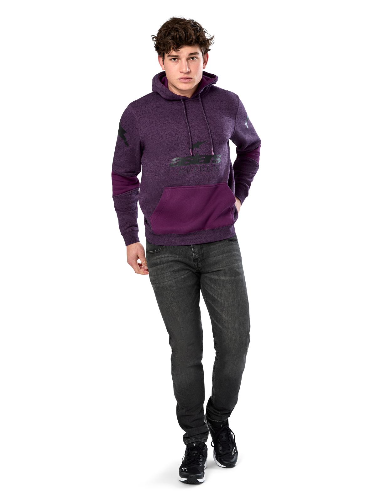 Alpinestars Perpetuate Hoodie, codzienna odzież streetwearowa, fioletowy polar melanżowy z ciemnofioletowymi wstawkami na kieszeni kangurce i rękawach, czarne logo na klatce piersiowej, kaptur ze sznurkiem, noszona przez modela z ciemnoszarymi dżinsami i czarnymi sneakersami