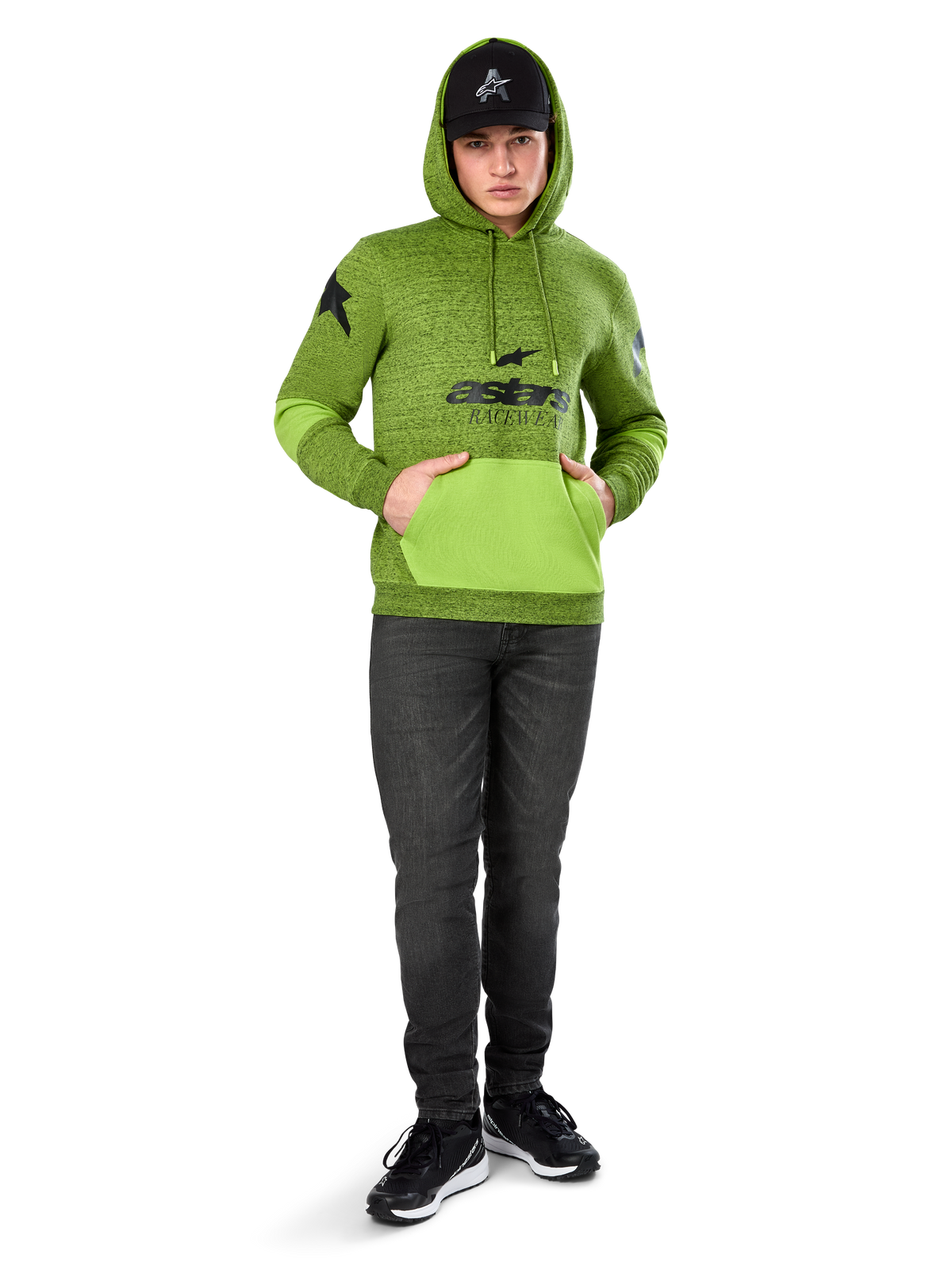 Alpinestars Perpetuate Hoodie, polarowa bluza w kolorze limonkowej zieleni (melanż) z kontrastową jaskrawozieloną kieszenią kangurka i panelami na rękawach, czarna grafika 'astars' z przodu, stylizowana z czarną czapką i ciemnymi dżinsami, codzienna odzież streetwearowa inspirowana sportami motorowymi