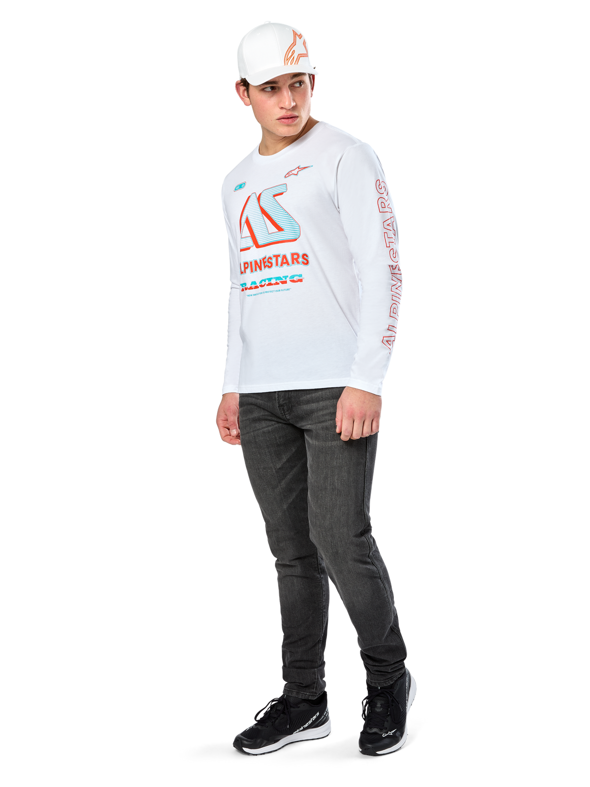 Alpinestars Ayess CSF Tee, koszulka z długim rękawem, biała, z dużą niebiesko-czerwoną grafiką wyścigową CSF na klatce piersiowej i czerwonym logo Alpinestars na rękawie, zestawiona z ciemnymi jeansami i białą czapką Alpinestars, casualowy styl motorsportowy