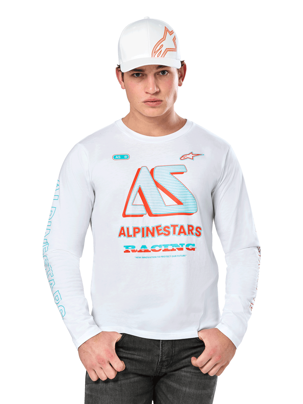 Alpinestars Ayess Csf Long Sleeve Tee, biała koszulka sportowa, kolorowe logo AS w kolorze niebieskim i czerwonym, grafika ALPINESTARS RACING, model w białej czapce i czarnych dżinsach, białe tło