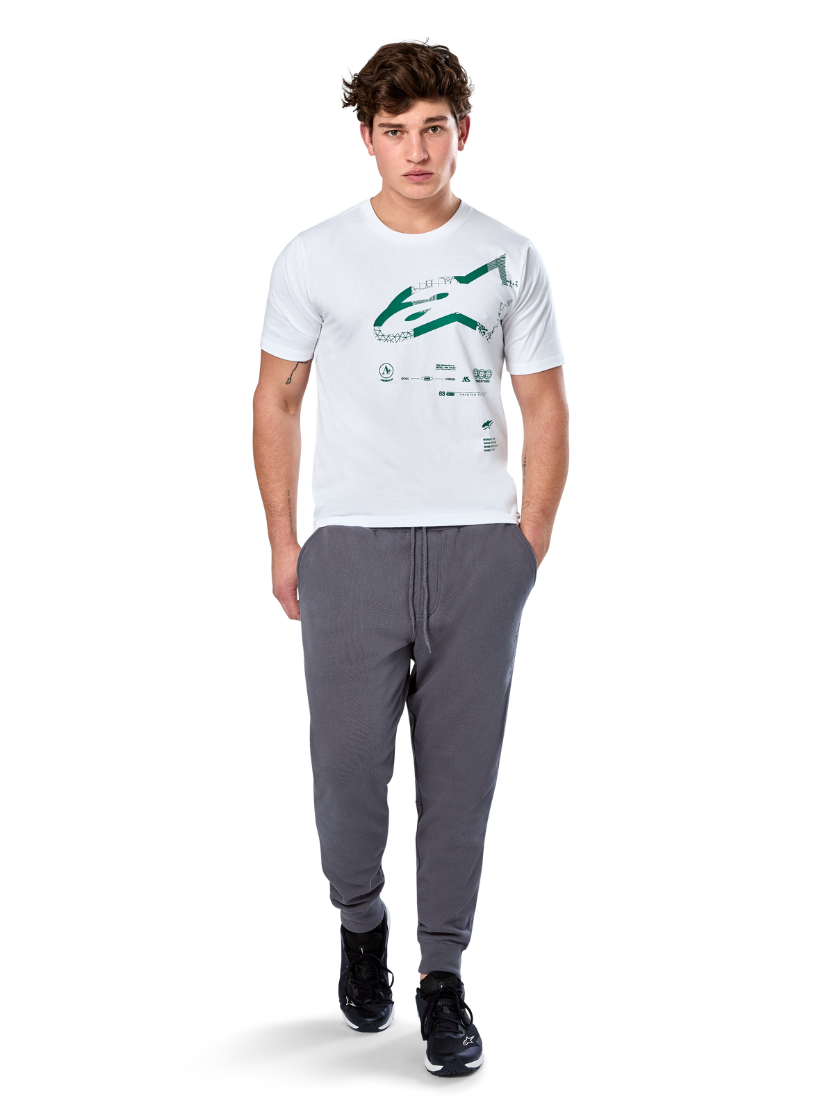 Alpinestars Geografica CSF Tee, koszulka z krótkim rękawem, biała, zielone logo Astars z geograficzną grafiką multi-tech, noszona z szarymi spodniami dresowymi i czarnymi sneakersami, codzienny motorsportowy styl streetwear