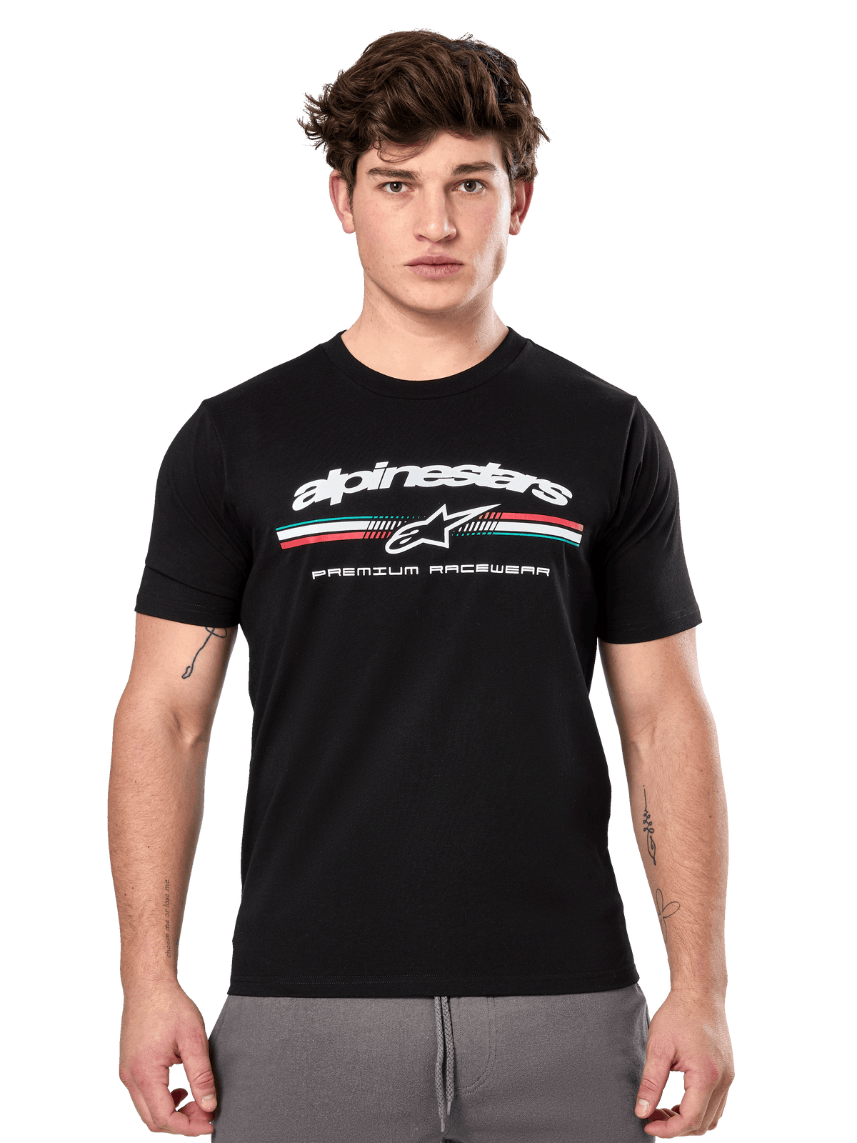 Alpinestars Prevail CSF Tee, czarna koszulka z krótkim rękawem prezentowana przez modela, białe logo z trójkolorowym paskiem i grafiką „PREMIUM RACEWEAR”, codzienna odzież uliczna w stylu motorsport