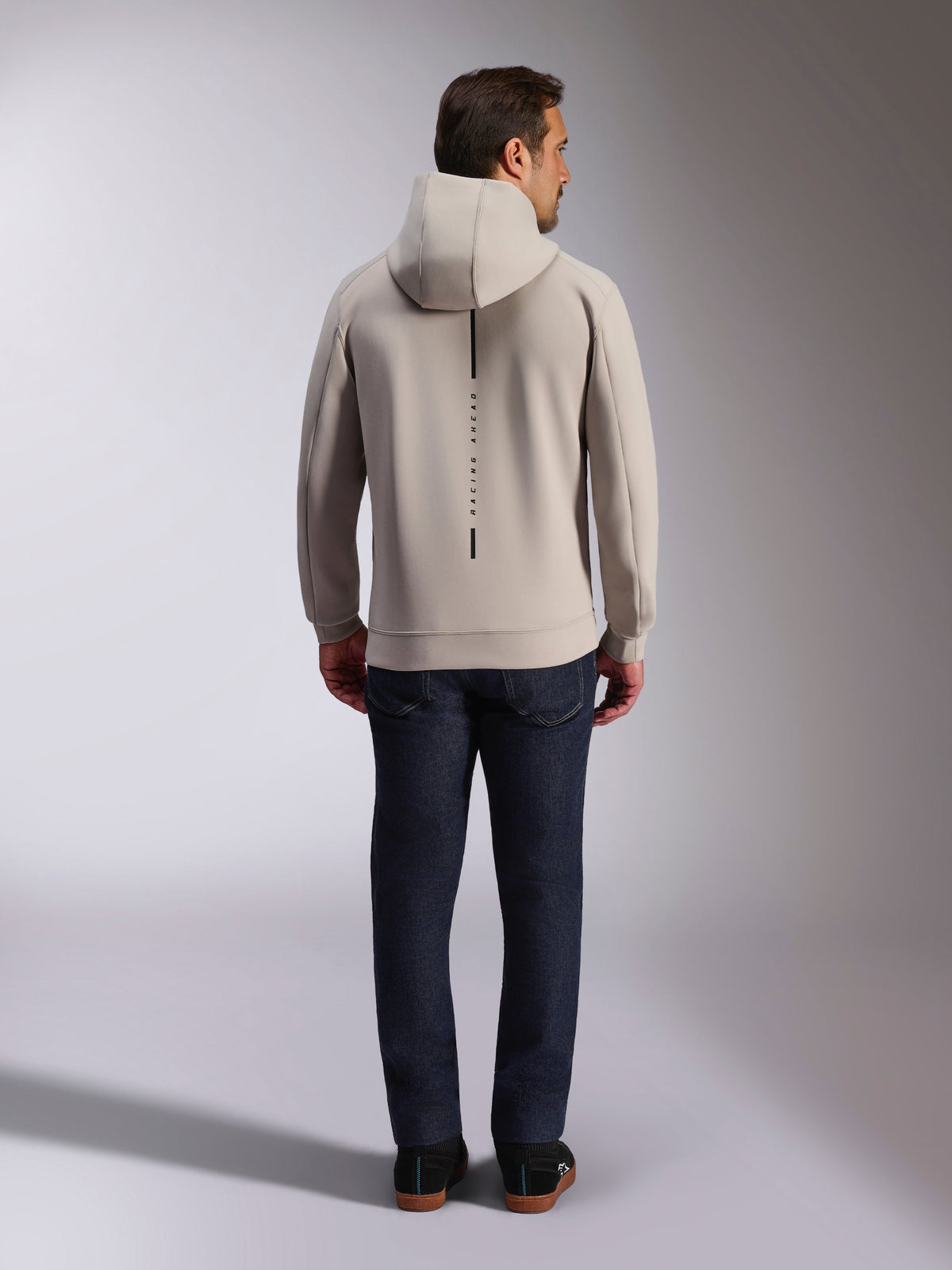 Bluza z kapturem Alpinestars Insight, widok z tyłu, szary cementowy, pionowy czarny pas z napisem „RACING AHEAD”, dwuwarstwowy polar, codzienna odzież typu streetwear inspirowana motorsportem