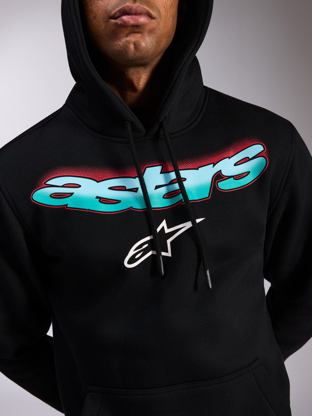 Alpinestars Ellipsoid Hoodie, czarna bluza z polaru typu pullover, napis Astars z gradientem morskiego błękitu i niebieskiego z czerwonymi akcentami typu halftone, białe logo z gwiazdą, kaptur ze sznurkiem, codzienna odzież streetwearowa inspirowana motorsportem