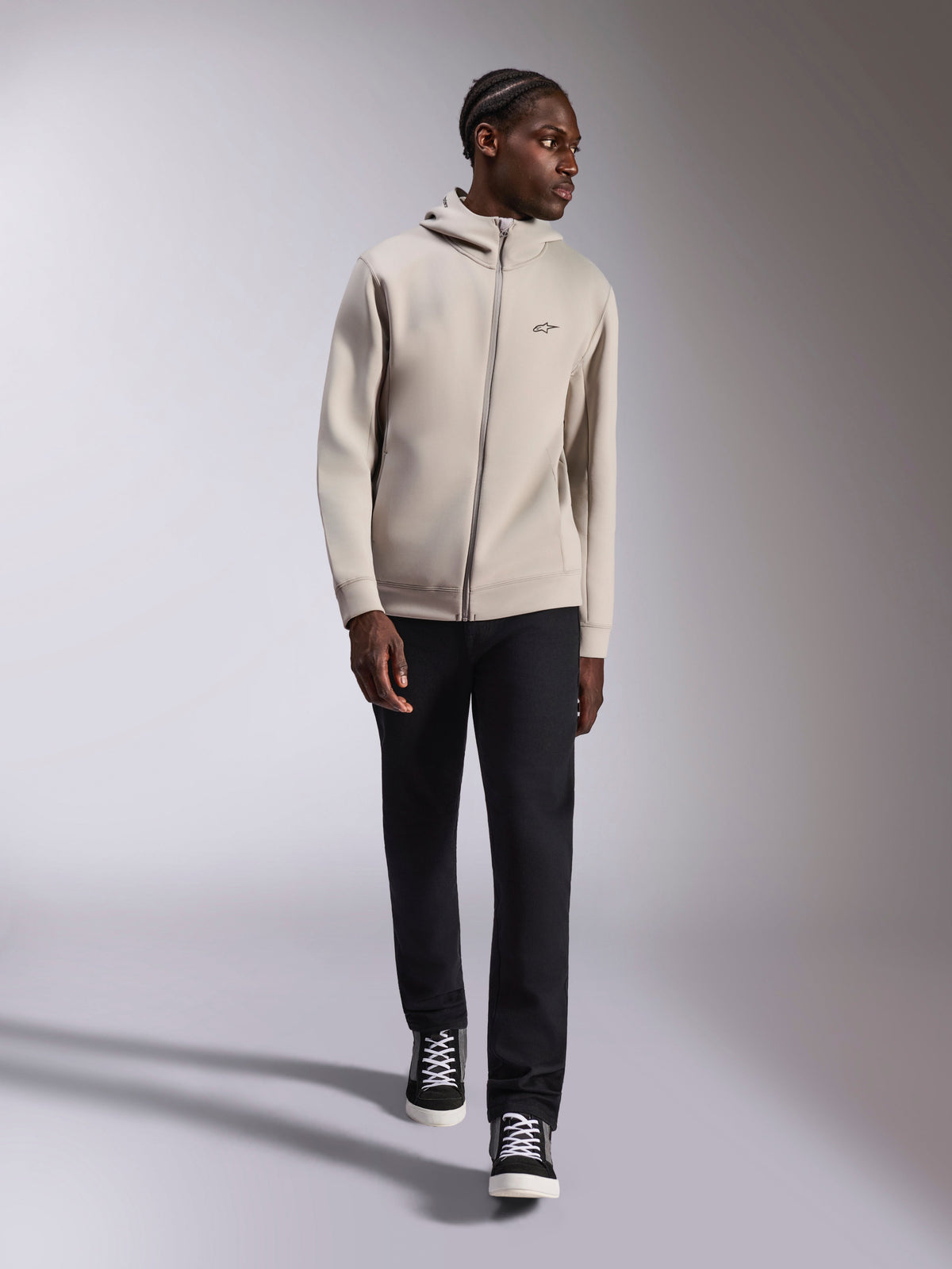 Alpinestars Cypher Hoodie, full-zip double face fleece hoodie, Cement Gray, worn by model with black pants and black and white sneakers, featuring a high-neck mesh-lined hood and small chest Astars logo, modern casual streetwear
