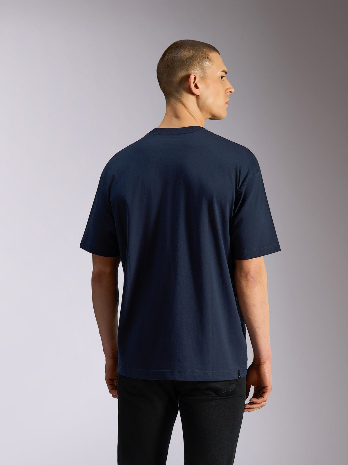 Alpinestars Aplomb Oversized CSF Tee, koszulka z krótkim rękawem, granatowa, widok z tyłu na modelu, luźny krój oversized, swobodny streetwear inspirowany sportami motorowymi