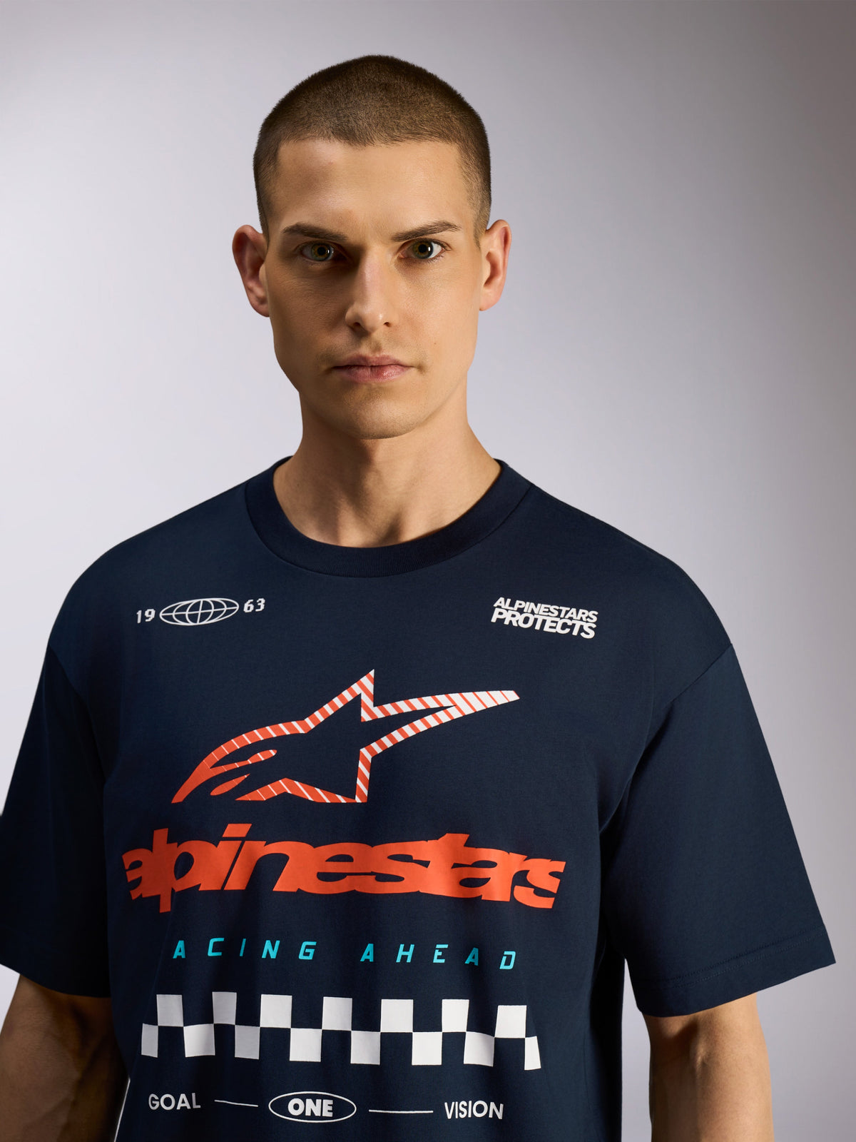Alpinestars Aplomb Oversized CSF Tee, granatowa koszulka z krótkim rękawem, duża grafika na piersi z czerwonym logo i białą szachownicą, codzienny motorsportowy streetwear