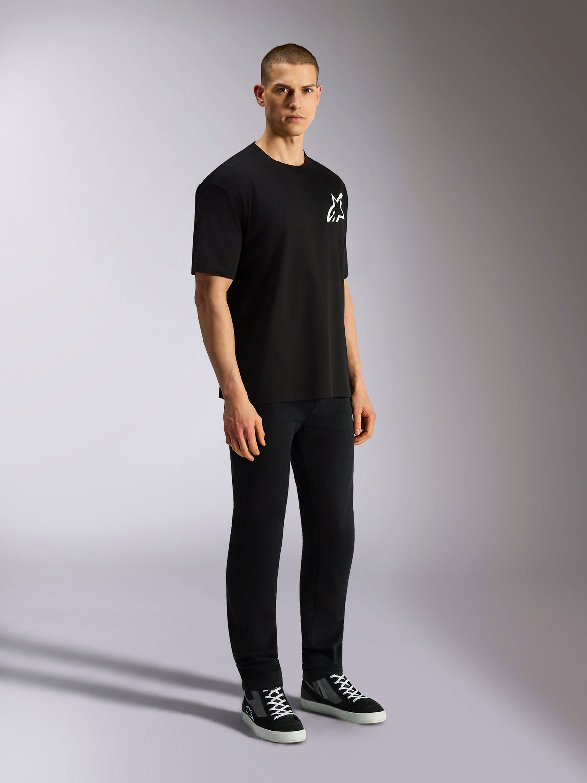 Alpinestars One Oversized CSF Tee, Short Sleeve T-Shirt, Black, white Astars logo on the chest, oversized fit, worn by a male model with black pants and sneakers, casual motorsport-inspired streetwear