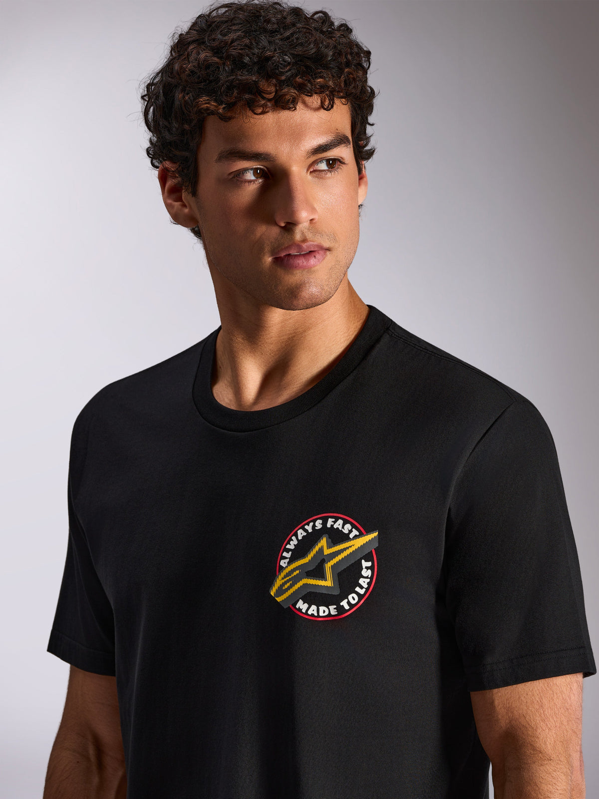 Alpinestars Aorbit CSF Tee, Short Sleeve T-Shirt, Black, Always Fast Made to Last circular chest graphic with yellow Astars logo, worn by model, Casual Motorsport Streetwear