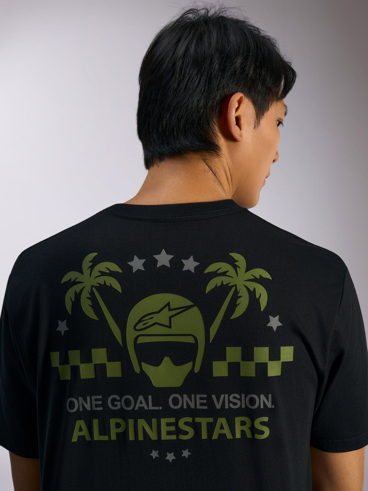 Alpinestars Order CSF Tee, koszulka z krótkim rękawem, czarna, widok z tyłu z zieloną grafiką kasku i palm, szarymi gwiazdami oraz napisem „ONE GOAL. ONE VISION. ALPINESTARS”, codzienna odzież motorsportowa typu streetwear