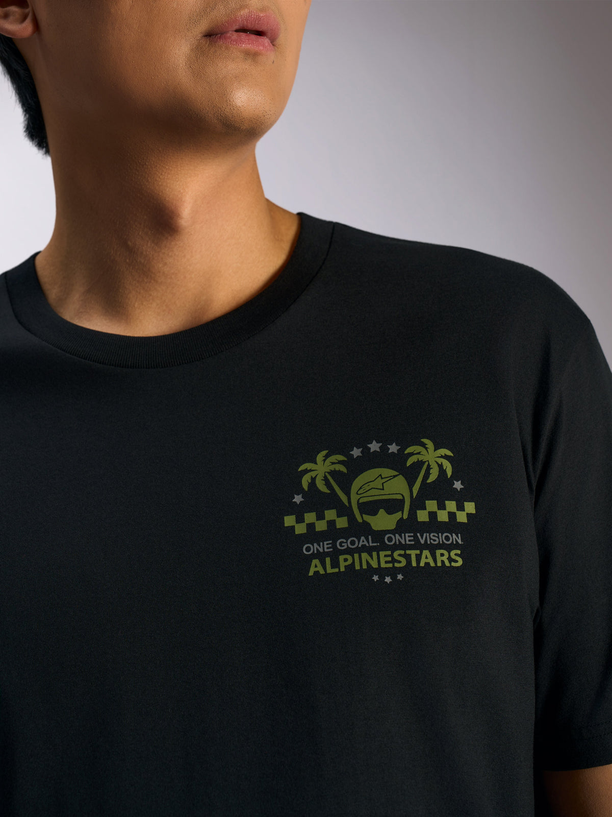 Alpinestars Order CSF Tee, czarna koszulka z krótkim rękawem, oliwkowa grafika z kaskiem i palmami na piersi, napis „ONE GOAL. ONE VISION.”, casualowa odzież w stylu motorsport