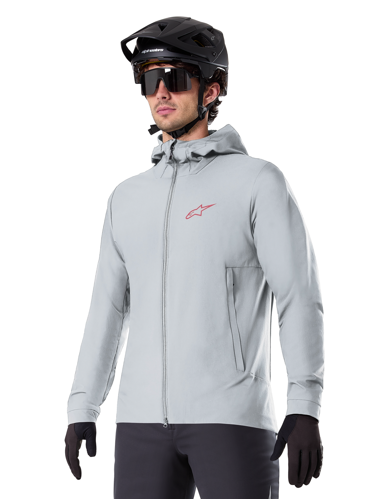 Alpinestars A-Dura Thermal Jacket, light gray insulated cycling jacket, hooded design with a small red logo, worn with a black helmet and gloves, technical mountain bike apparel for cold-weather riding