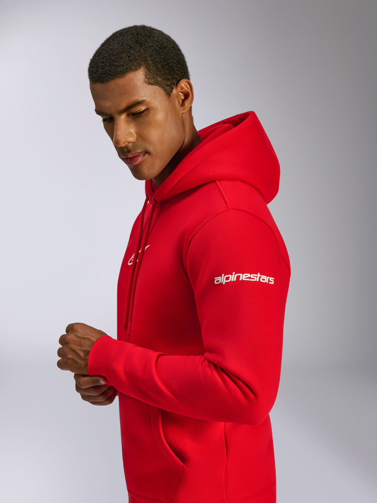 Alpinestars Frontal Hoodie, Red, pullover fleece hoodie worn by a model, featuring white Alpinestars wordmark on the sleeve, front logo, kangaroo pocket, and drawstring hood, casual motorsport-inspired design