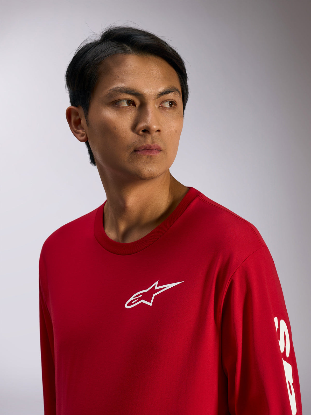 Alpinestars Trackside CSF Tee, koszulka z długim rękawem, czerwona z białym logo Alpinestars na piersi i napisem na rękawie, casualowy streetwear motorsportowy, portret lifestylowy