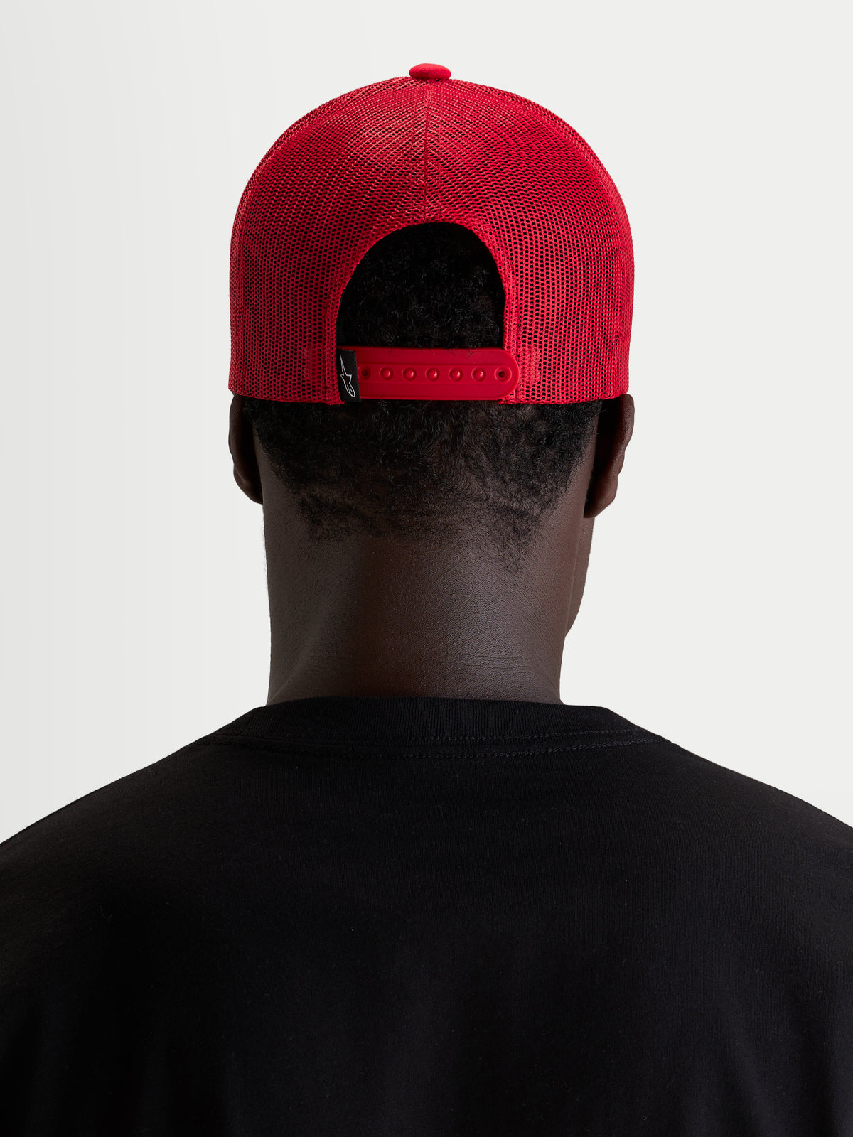 Alpinestars Ageless Snapback Hat, czerwona czapka sportswear, widok z tyłu przedstawiający regulowane zapięcie snapback i panel z siatki na modelu