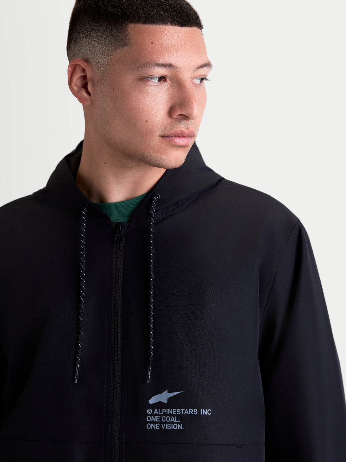 Alpinestars Speeder Resolve, lekka męska kurtka ochrona przed wiatrem, czarna, z kapturem i nakrapianymi sznurkami, logo Alpinestars na piersi, miejska odzież sportowa z poliestru, widok na modelu.