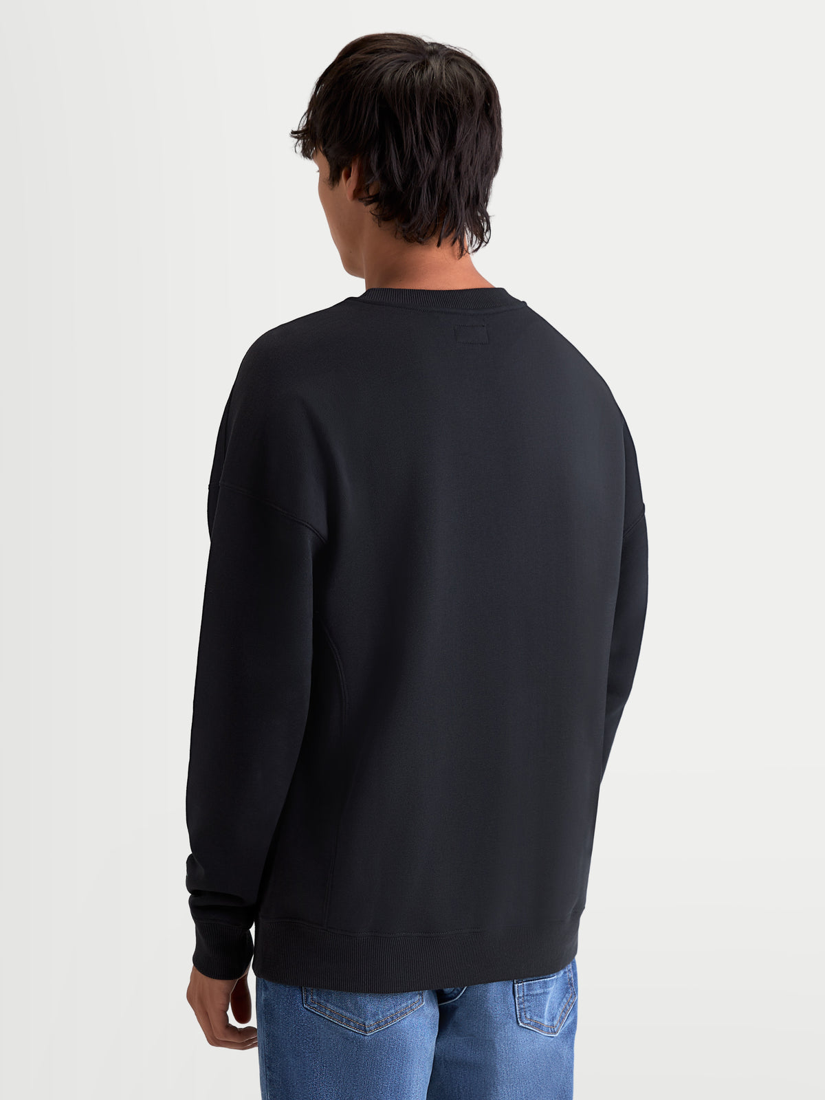 Alpinestars Bluza Guise Oversize, męska bluza z polaru typu crewneck, czarna, swobodny krój oversize, widok z tyłu pokazujący prążkowany dół, codzienna odzież sportowa inspirowana motorsportem