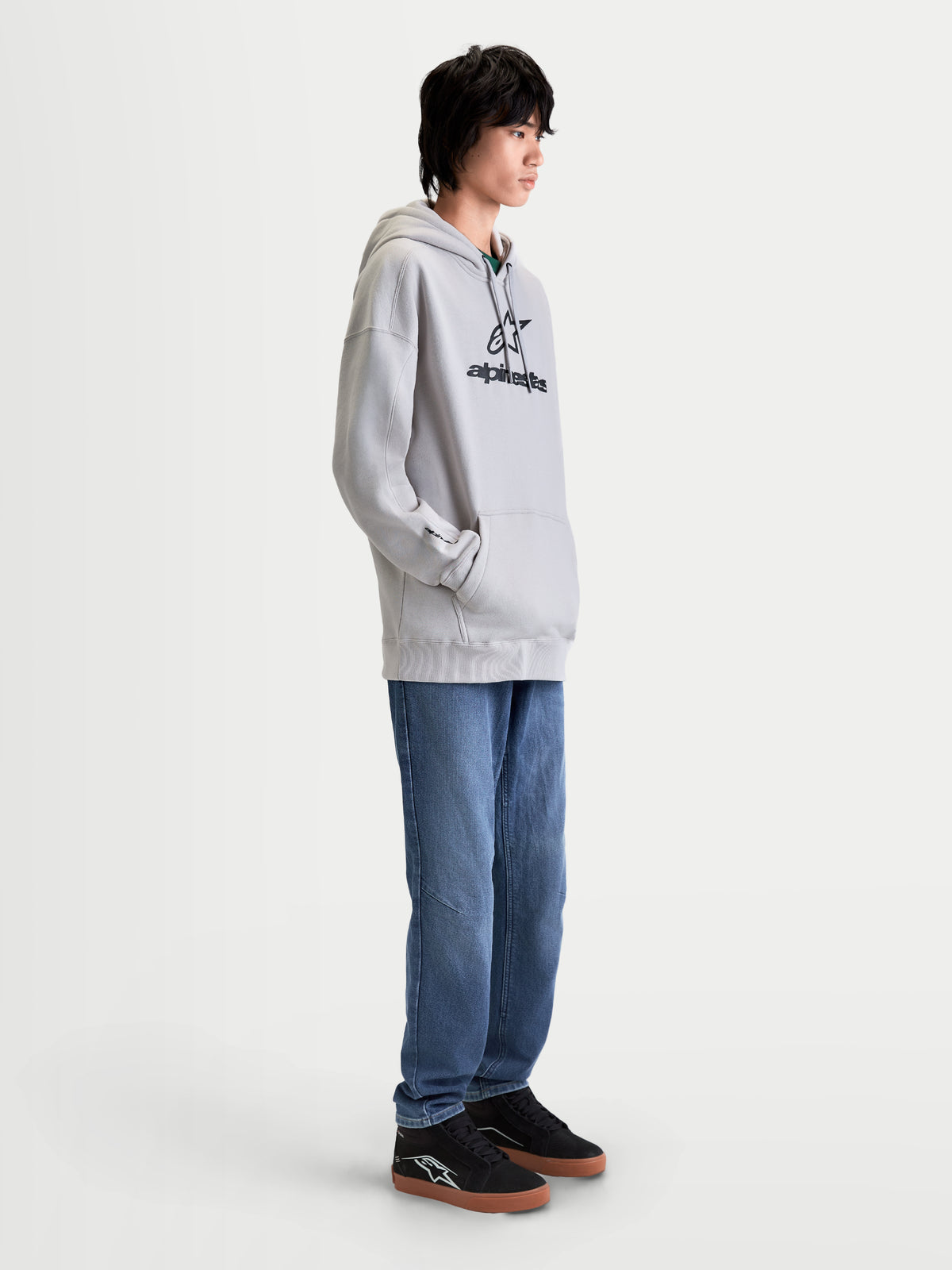 Alpinestars bluza z kapturem Prelude Oversize, męska sportowa bluza typu polar, szara z czarnym wypukłym logo z przodu, luźny krój, kieszeń kangurka i kaptur z podszewką. Casualowa odzież sportowa.
