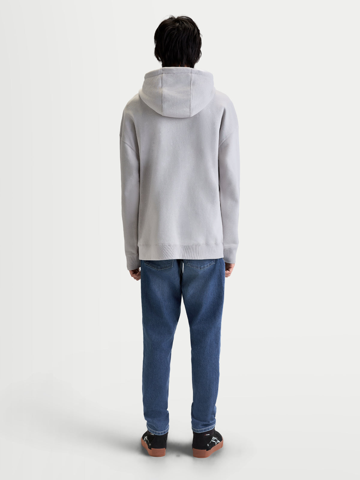 Alpinestars Prelude Oversize, męska bluza z kapturem, szara, polarowa odzież sportowa, widok z tyłu na modelu, luźny krój typu oversize, ściągacze przy mankietach i na dole.