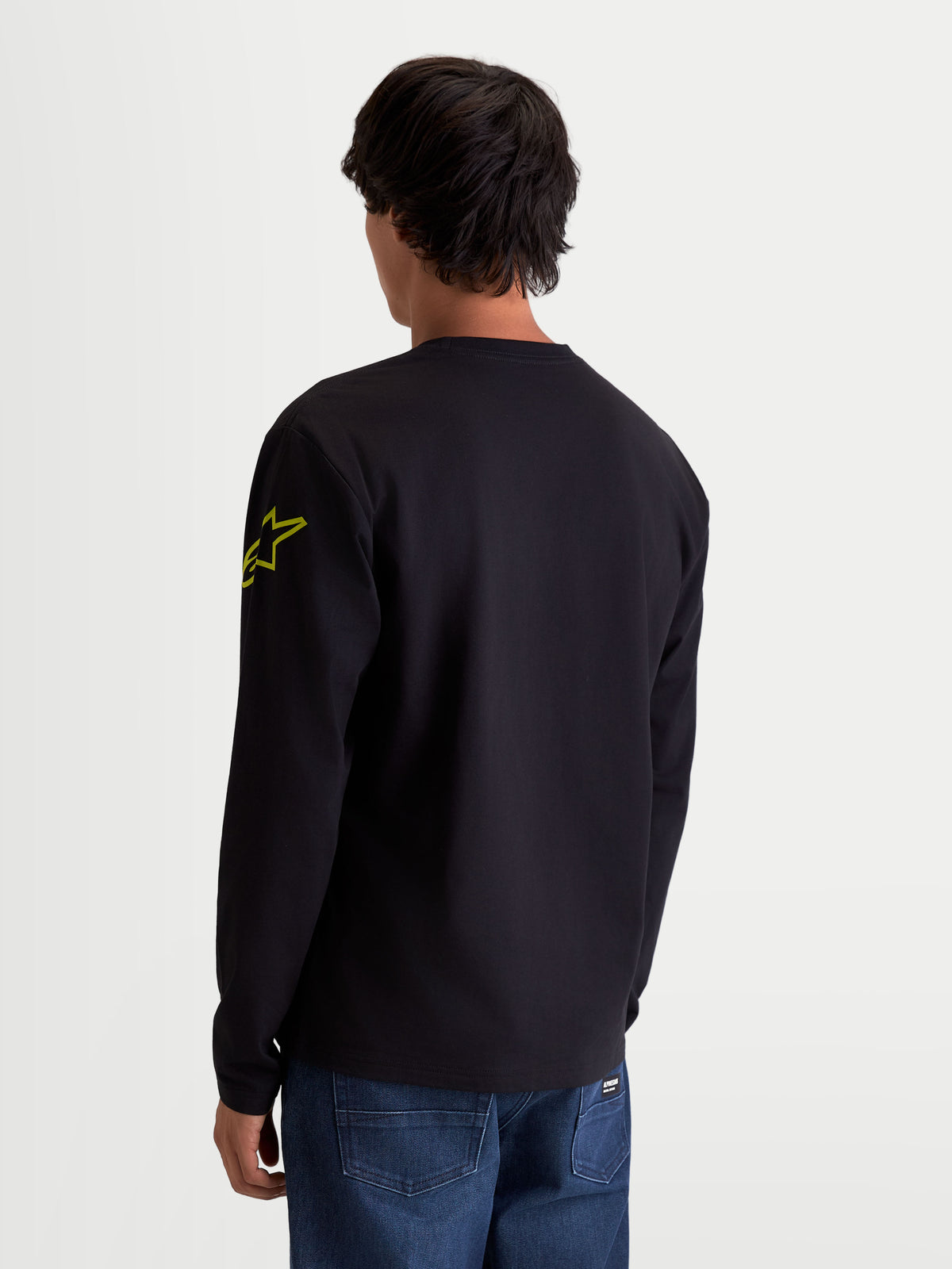 Alpinestars Koszulka Velocifier CSF, koszulka sportswear z długim rękawem, czarna i żółta, logo Astars na ramieniu i prążkowane mankiety, widok z tyłu na modelu, mieszanka bawełny i poliestru z recyklingu.