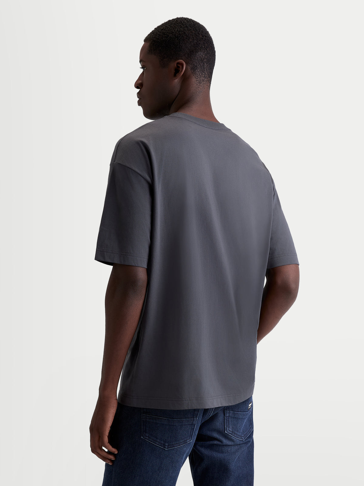 Alpinestars Chalk Oversized CSF Tee, męska i damska koszulka sportowa typu casual, szara, widok z tyłu z boku na modelu prezentujący luźny krój oversize oraz konstrukcję z mieszanki bawełny i poliestru.