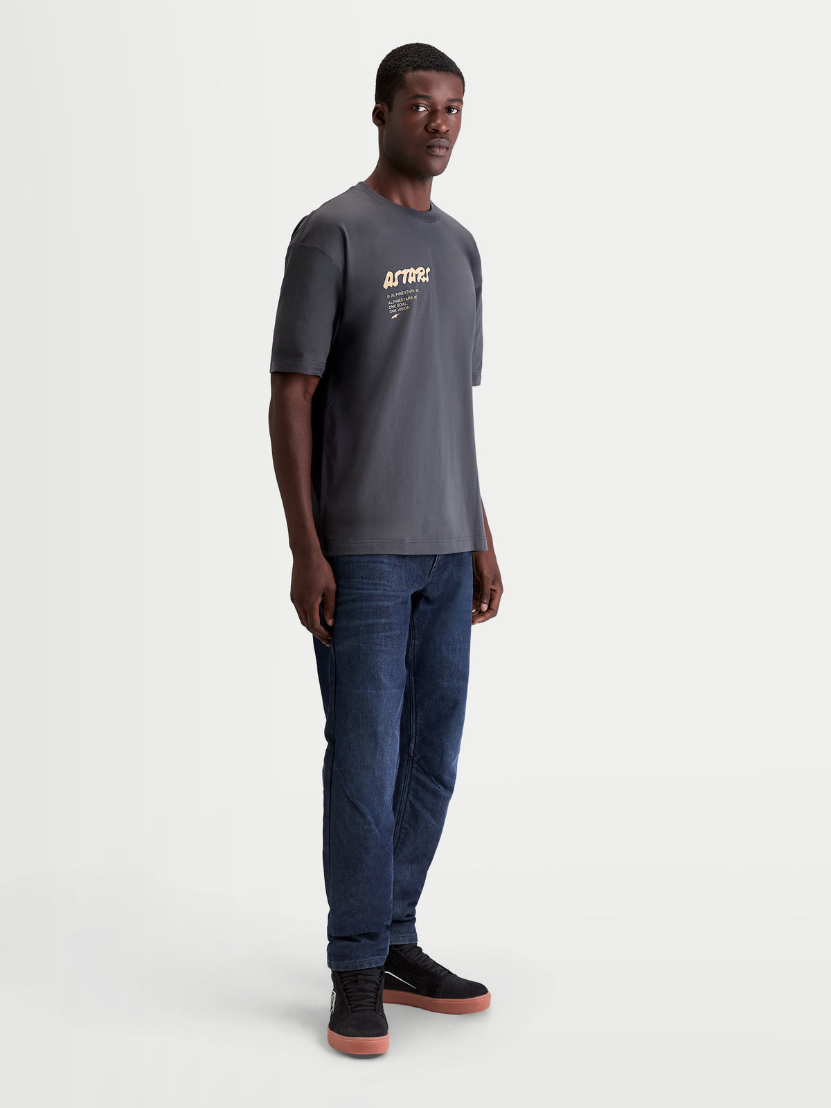 Alpinestars Koszulka Chalk Oversized CSF, męska koszulka sportswear z krótkim rękawem, szara, luźny fason oversize, grafika Astars na klatce piersiowej, prezentowana na modelu, styl inspirowany motorsportem.