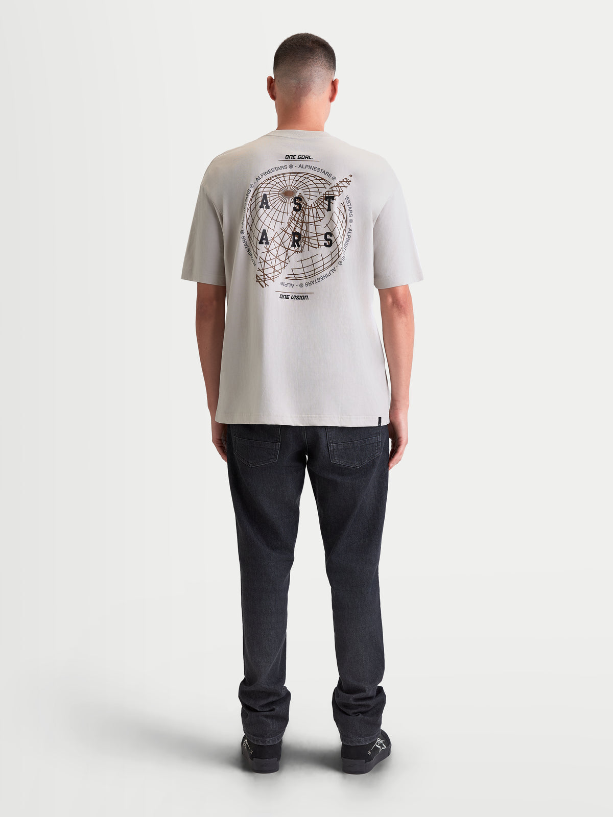 Alpinestars Latitude Oversized CSF Tee, męska koszulka z krótkim rękawem, kolor szary, widok z tyłu na modelu, duża grafika z motywem globu i logotypem na plecach, luźny krój oversized, codzienna odzież sportowa.