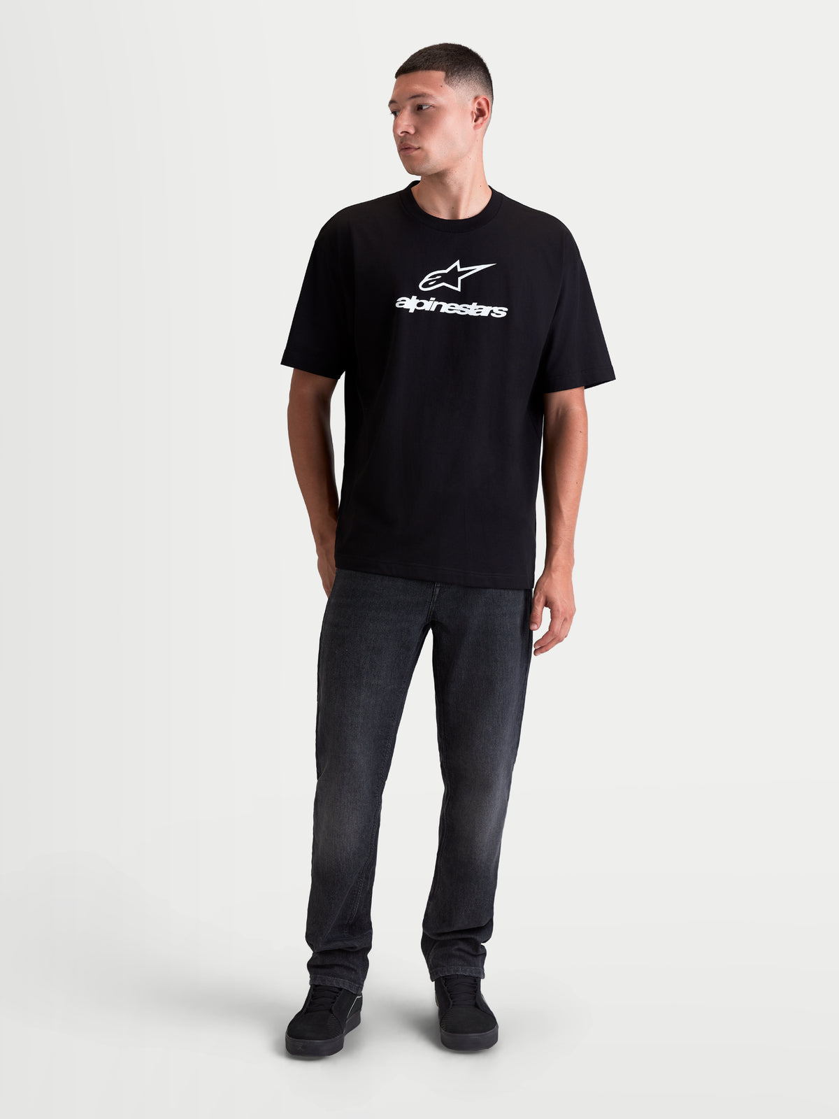 Alpinestars Prelude Oversized CSF Tee, czarna koszulka z krótkim rękawem, białe logo graficzne z przodu, luźny krój, bawełniano-poliestrowa odzież sportowa, widok z przodu na modelu.
