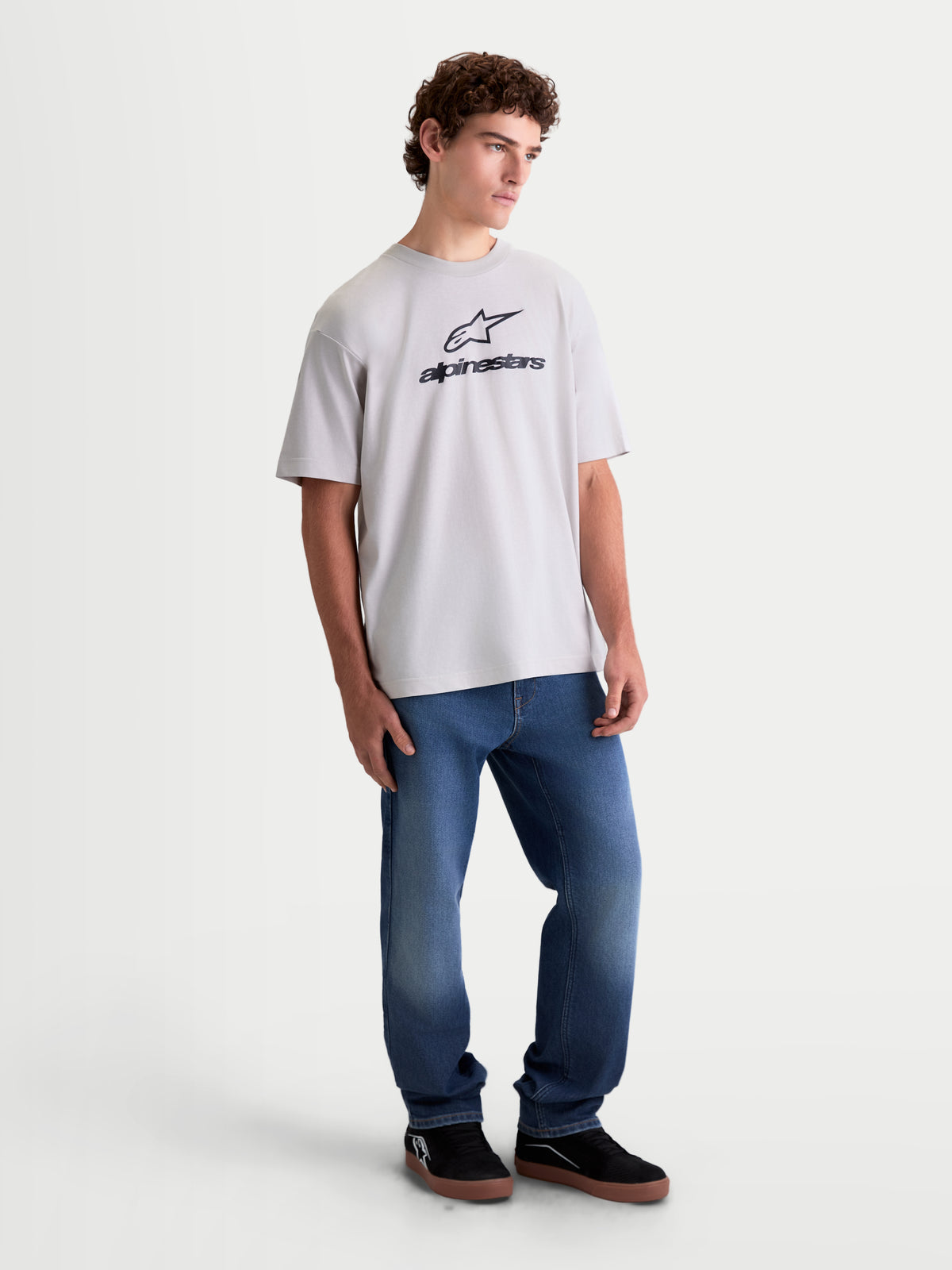 Alpinestars Prelude Oversized CSF Tee, męska koszulka z krótkim rękawem na modelu, szary kolor cementowy z czarnym logo Astars na piersi, luźny krój oversize, casualowa odzież sportowa.