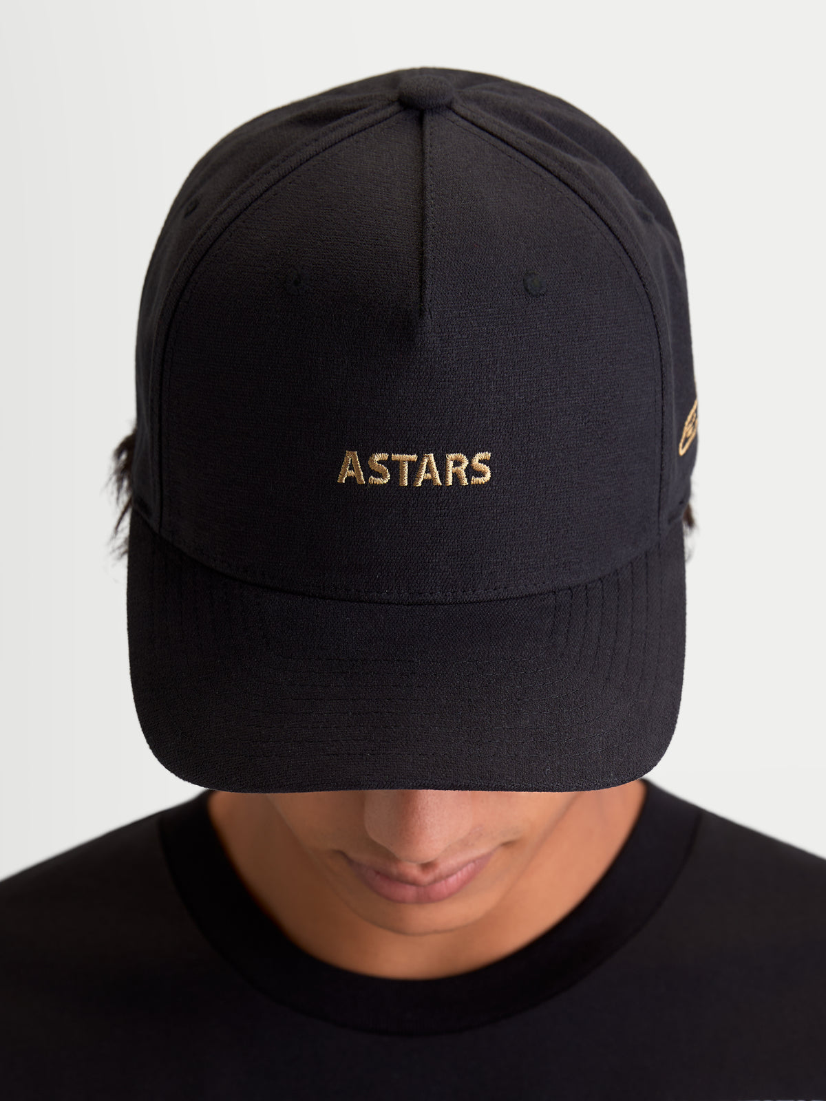 Alpinestars Czapka Z Daszkiem County Canvas, czarna czapka z daszkiem sportswear, złoty haft logo ASTARS, zakrzywiony daszek i usztywniona korona, tkanina oxford peached, widok na modelu.