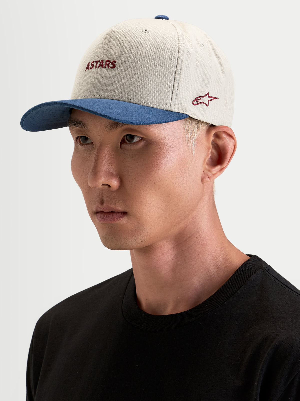 Alpinestars County Canvas Hat, czapka z daszkiem sportswear w kolorze piaskowym i niebieskim, na modelce, z zakrzywionym daszkiem i haftowanym logo Astars