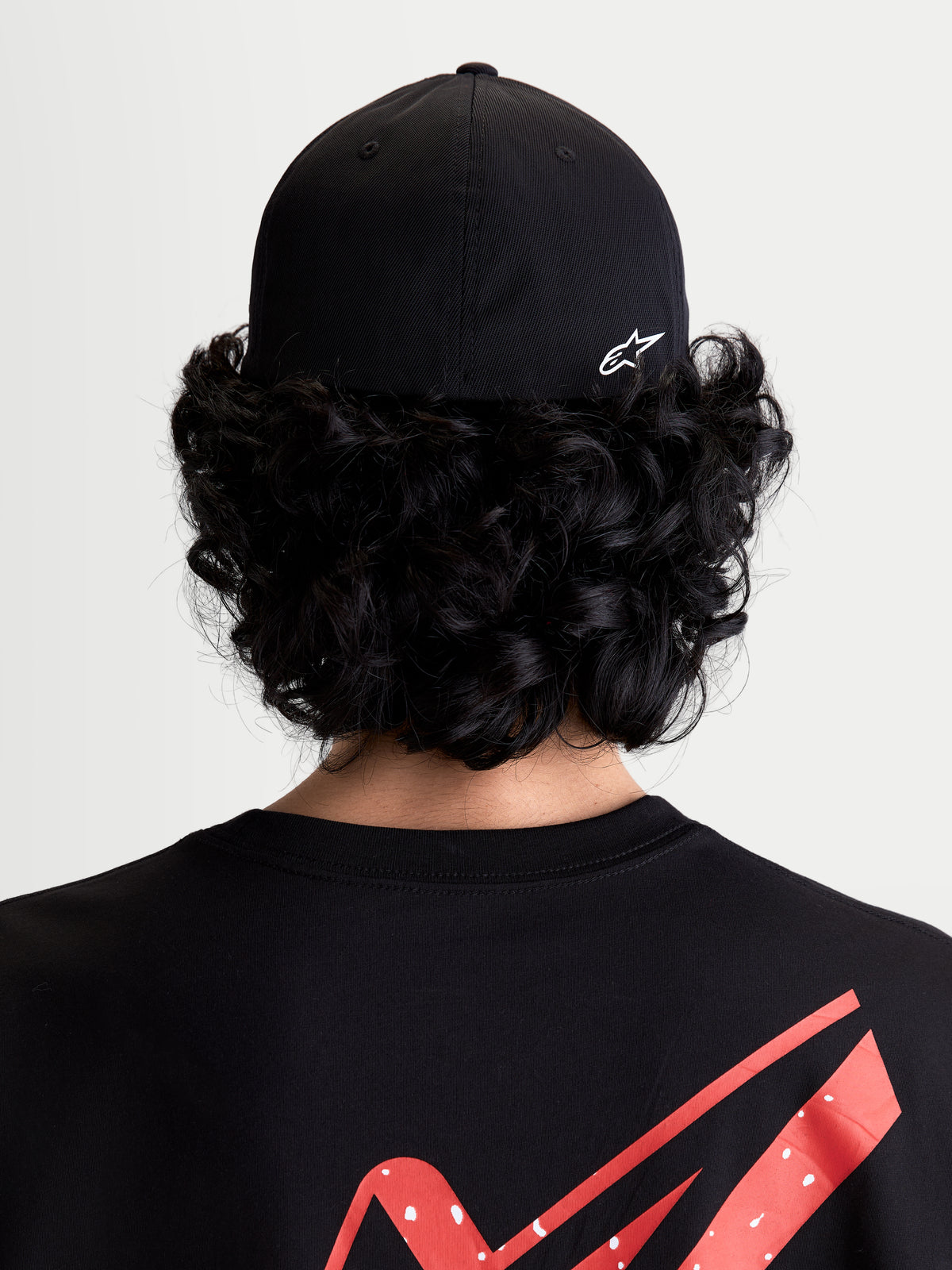 Alpinestars Czapka Points, czapka sportswear z daszkiem, czarna i biała, lekka konstrukcja z nylonu tactel, elastyczny tył flex back, widok z tyłu na modelu z białym nadrukiem logo Astars HD.