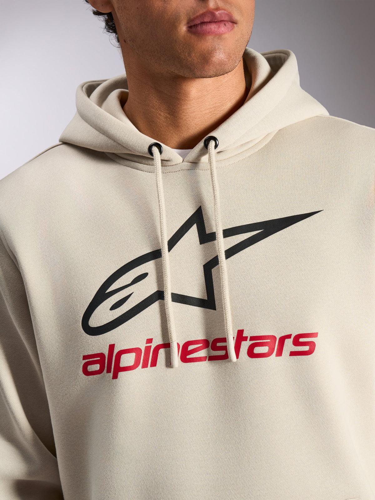 Alpinestars Always V3 Hoodie, bluza z kapturem streetwear, kolor złamanej bieli z czarnym logo gwiazdy i czerwonym napisem Alpinestars, kaptur ze sznurkami, polar premium, nowoczesny design inspirowany sportami motorowymi