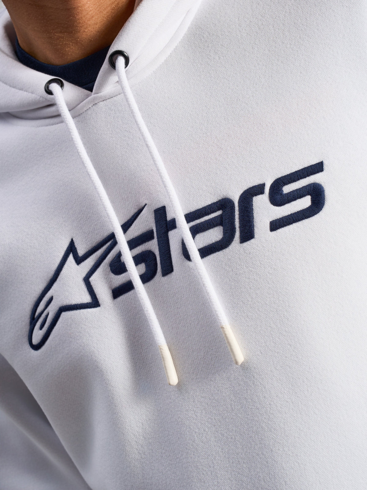 Alpinestars Blaze V3 Hoodie, White Navy, close-up of chest featuring navy blue front logo print and white drawstrings with dipped tips, casual motorsport streetwear