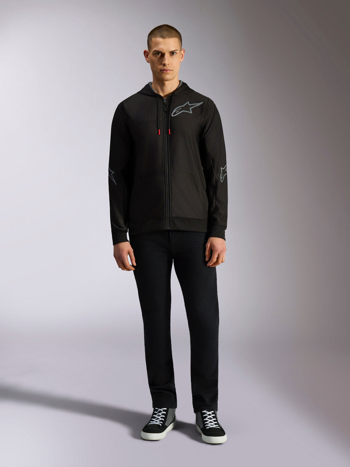 Alpinestars Sessions V3 Hoodie, rozpinana bluza z polaru z kapturem, czarna z szarym logo Astars na piersi i rękawach, sznurki z czerwonymi końcówkami, codzienna odzież streetwearowa inspirowana motorsportem