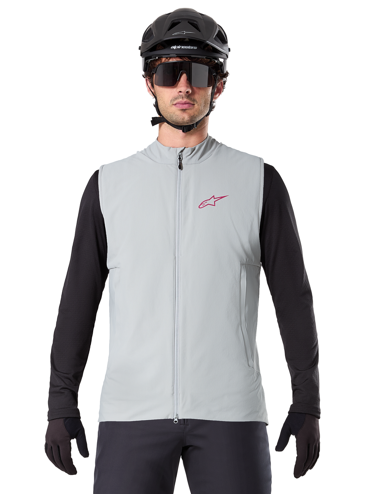 Alpinestars A-Dura Thermal Vest, kamizelka rowerowa, szary Titanium, noszona z czarną koszulką z długim rękawem i czarnym kaskiem rowerowym, czerwone logo gwiazdy Alpinestars na piersi, lekka i ocieplana konstrukcja do kolarstwa górskiego