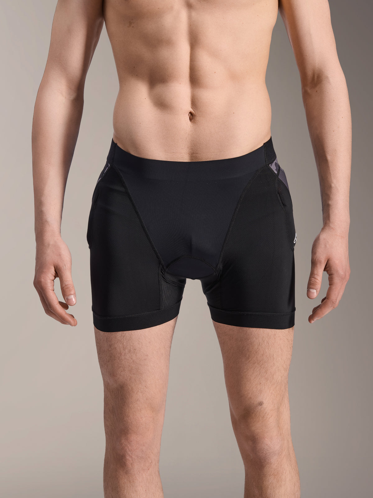 Bokserki ochronne Alpinestars A-Motion Plasma, szorty ochronne MTB, czarne z akcentami Black Camo, widok z przodu na modelu, oddychająca elastyczna siateczka i zintegrowana ochrona bioder zapewniająca wydajność podczas jazdy na rowerze