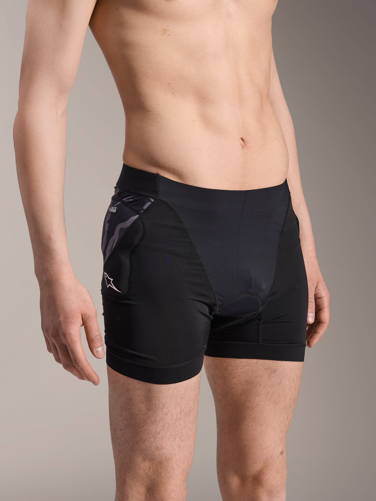 Bokserki ochronne Alpinestars A-Motion Plasma, czarne rowerowe spodenki termoaktywne, ochraniacz bioder z wzorem moro i białym logo Astar, oddychająca tkanina siateczkowa, odzież ochronna do kolarstwa górskiego