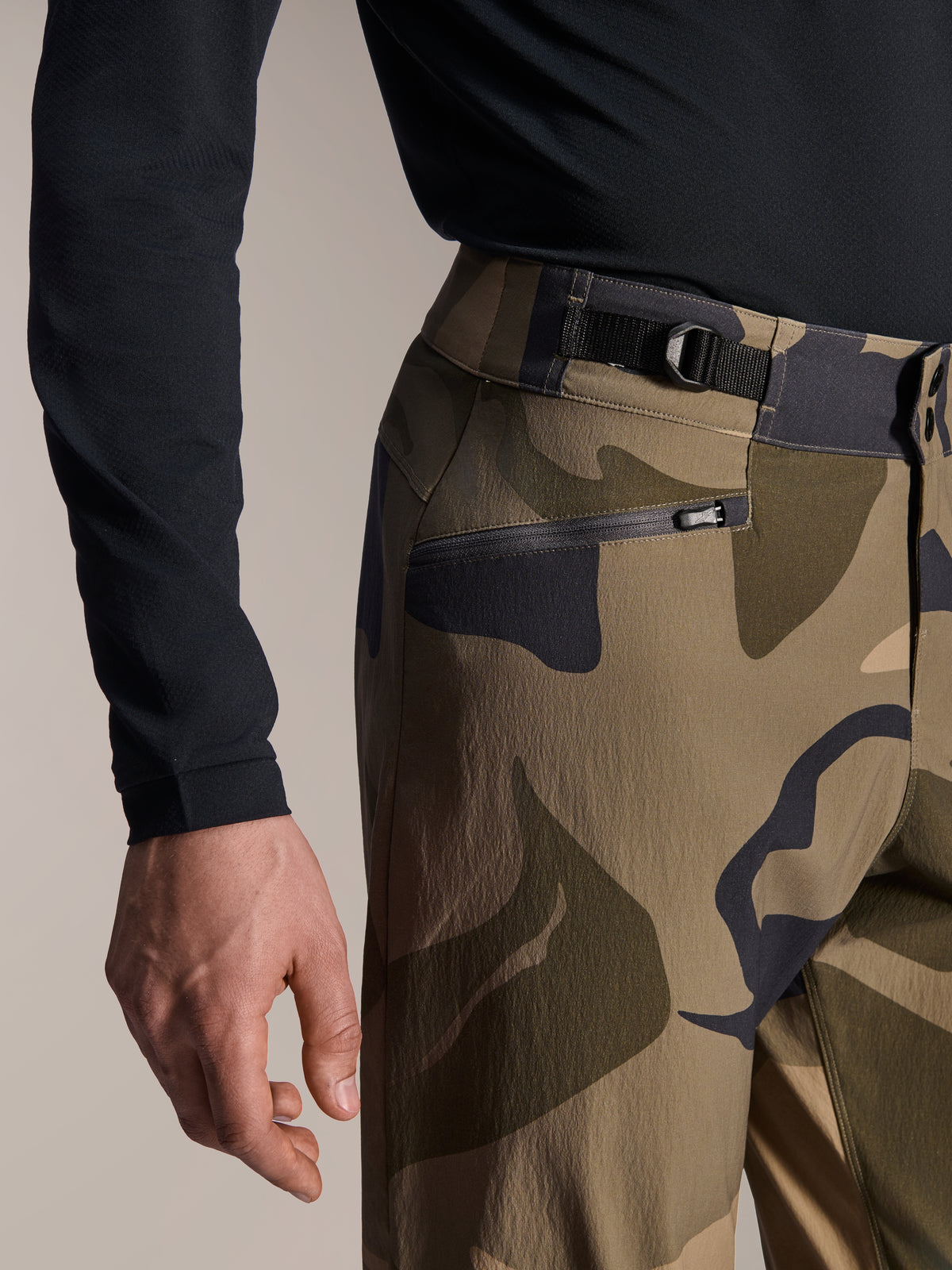 Alpinestars A-Dura Camo Pant, MTB Pants, Brown Camouflage, close-up view of the adjustable side cinch waist strap and zippered mesh-lined pocket, durable 2-way stretch textile for mountain biking