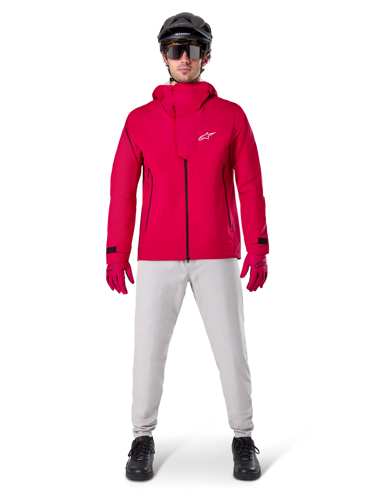 Alpinestars A-Dura Waterproof Pants, MTB Pants, Titanium Gray, worn with a bright red hooded jacket, red gloves, and a black mountain bike helmet, professional waterproof cycling gear for wet trail conditions