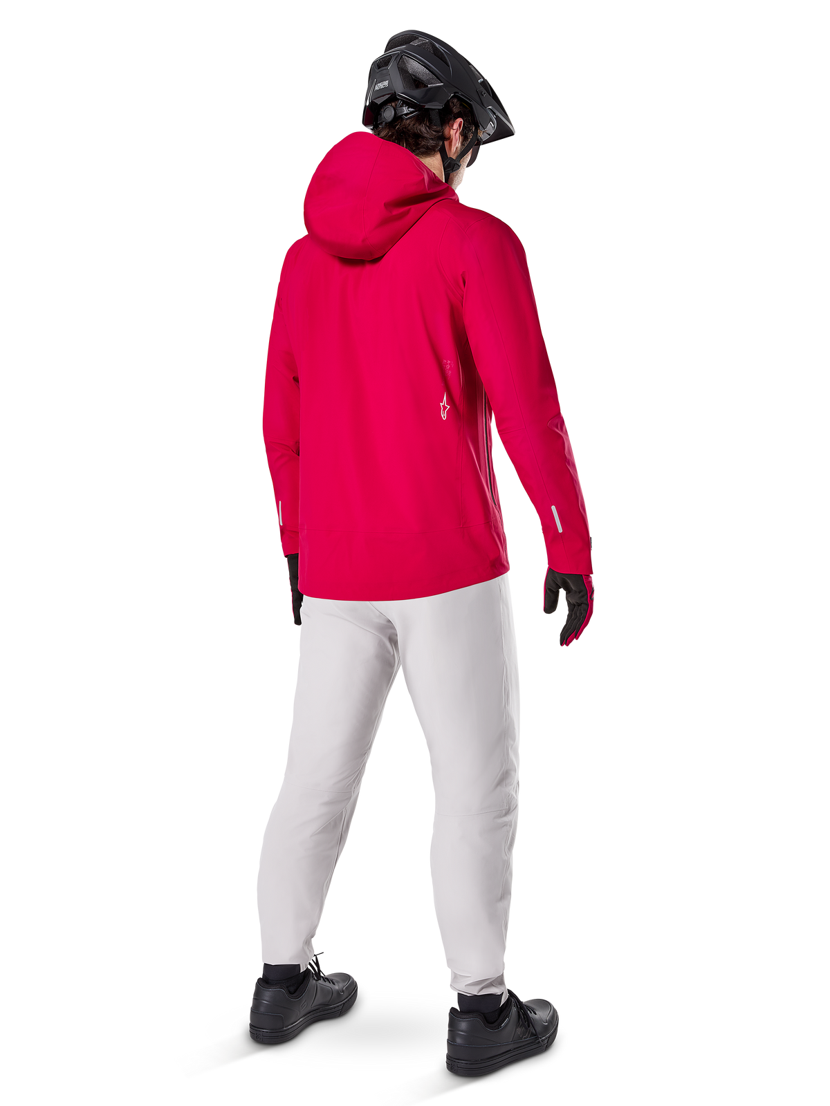 Alpinestars A-Dura Waterproof Pants in Titanium, rear view of a rider wearing the light gray technical mountain bike pants with a bright red hooded jacket and black helmet, durable waterproof gear for cycling in wet conditions