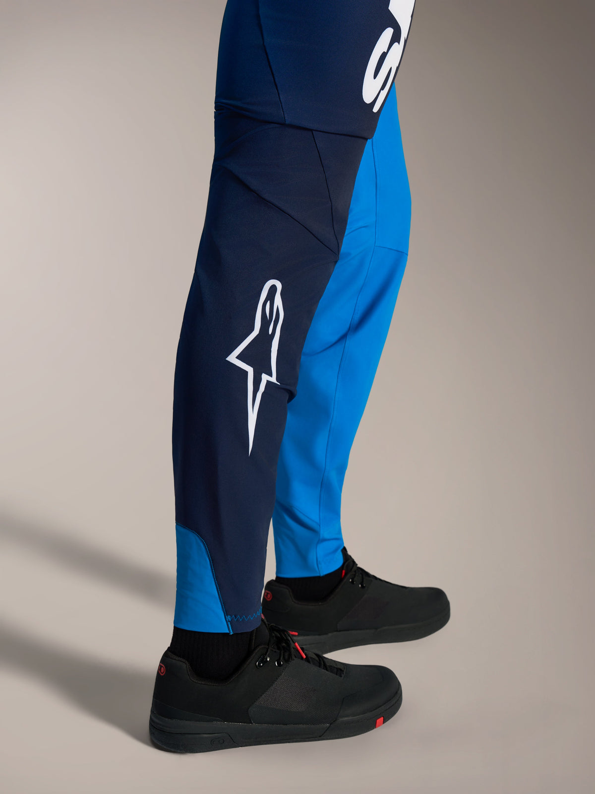 Spodnie MTB Alpinestars A-Supra Elite, cieniowany niebieski, białe logo Astars, dopasowany krój wyścigowy.