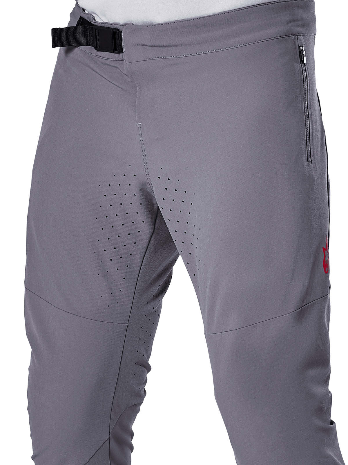 Alpinestars A-Aria Elite Pants, spodnie rowerowe MTB, ciemnoszare, zbliżenie przedstawiające magnetyczne zapięcie na klamrę, boczną kieszeń na zamek oraz laserowo wycinane perforacje wentylacyjne na wewnętrznej stronie ud, zaprojektowane z myślą o wydajności na szlaku.