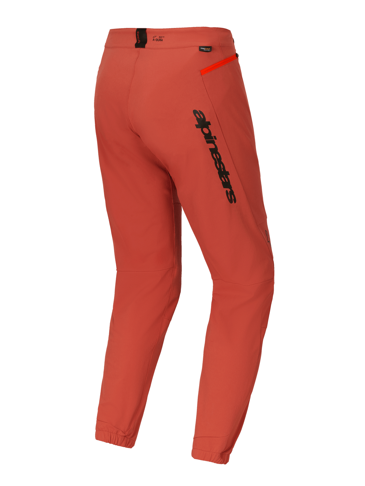 Spodnie Alpinestars A-Dura Elite, spodnie na rower górski (MTB), ciemnopomarańczowe, widok z tyłu pod kątem trzech czwartych, wyraźne czarne logo Alpinestars na udzie, jaskrawopomarańczowy akcent zamka na biodrze, elastyczne ściągacze w kostkach, techniczna odzież rowerowa