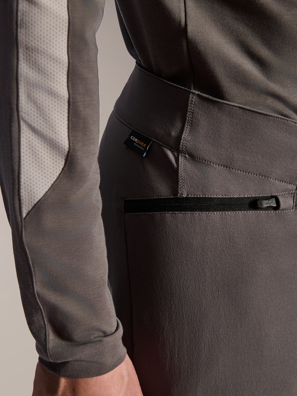 Alpinestars A-Dura Elite Pants, Dark Gray mountain bike pants, close-up detail of zippered side pocket and Cordura fabric tag, durable 4-way stretch textile for off-road performance