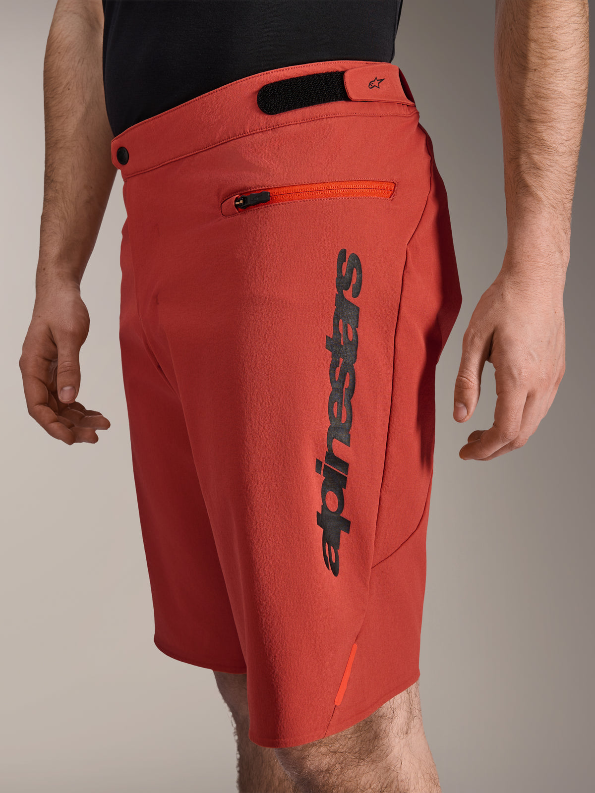 Alpinestars A-Dura Elite Shorts, spodenki rowerowe MTB, ciemnopomarańczowe, z pionowym czarnym logo Alpinestars na boku, kieszenią na zamek i regulacją w pasie na rzepy, wytrzymała odzież rowerowa do jazdy w terenie
